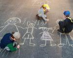 three children drawing a family with chalk on the road