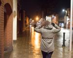 Woman walking down a street in the dark