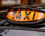 close up of a black cab illuminated taxi sign