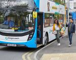 family boarding a bus - the parents are swinging their young child between them