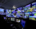 A photo of the inside of North Somerset Council's CCTV control room showing a person at a desk looking at multiple screens