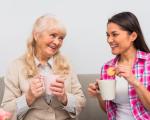 Two people having drinks together - one holding a biscuit