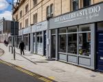 Person walking outside renovated and restored shop fronts on Walliscote Road in Weston-super-Mare