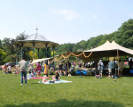 A photo of a stretch tent in Grove Park with people enjoying a summer event