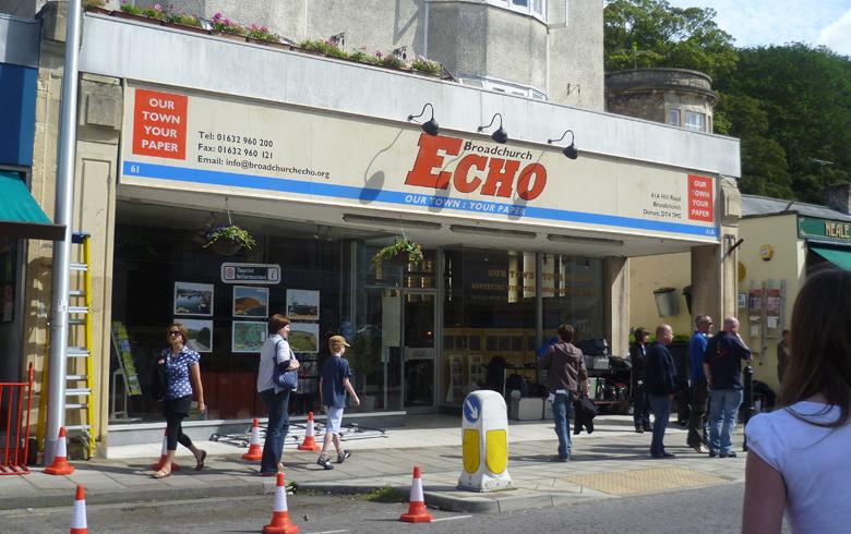 A shop front in Clevedon fitted out to look like the Broadchurch Echo newspaper, with a red sign above the door and signs in the windows