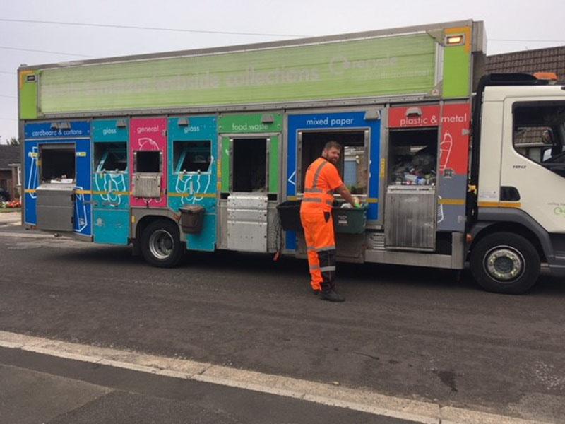 bin man wearing orange overalls stood next to a North Somerset recycling lorry