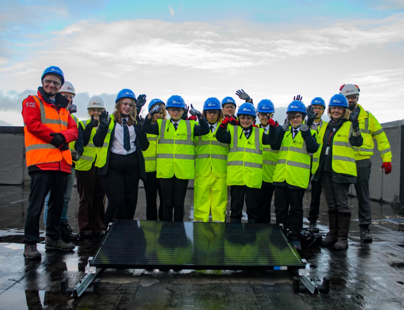 Winterstoke Hundred Academy pupils fit the first solar panel to the roof of their new school building