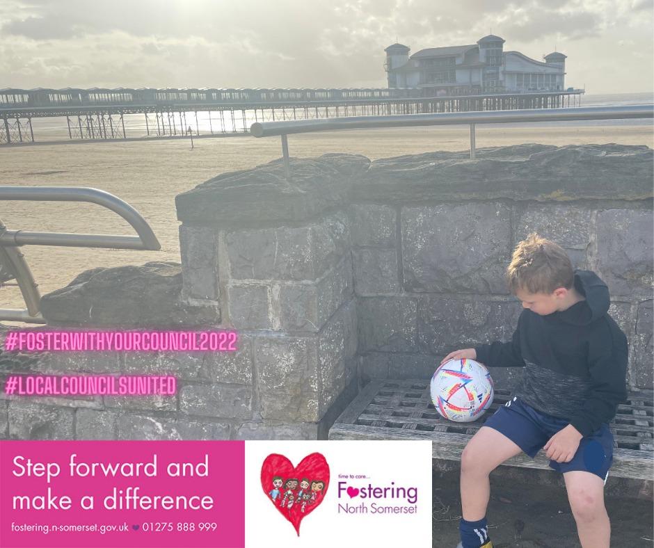 A photo of a young boy holding a football while sitting on a bench on the seafront in Weston-super-Mare.