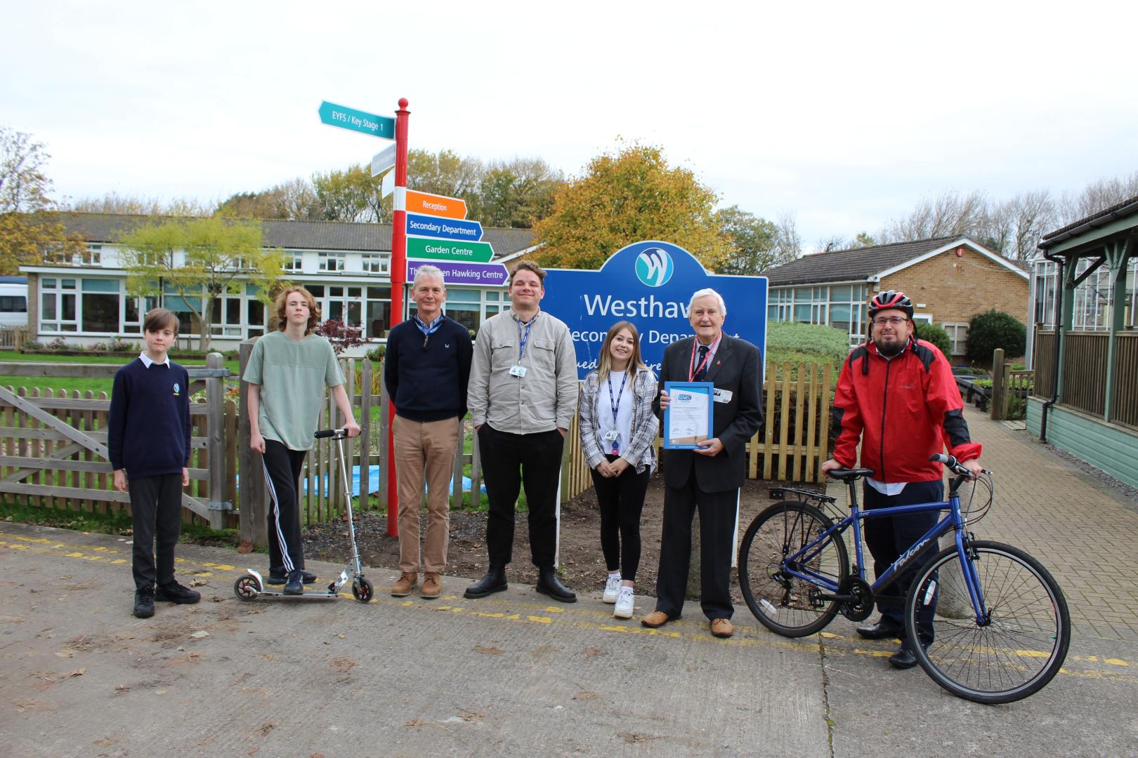 Students, Head and guests stood in front of Westhaven School sign