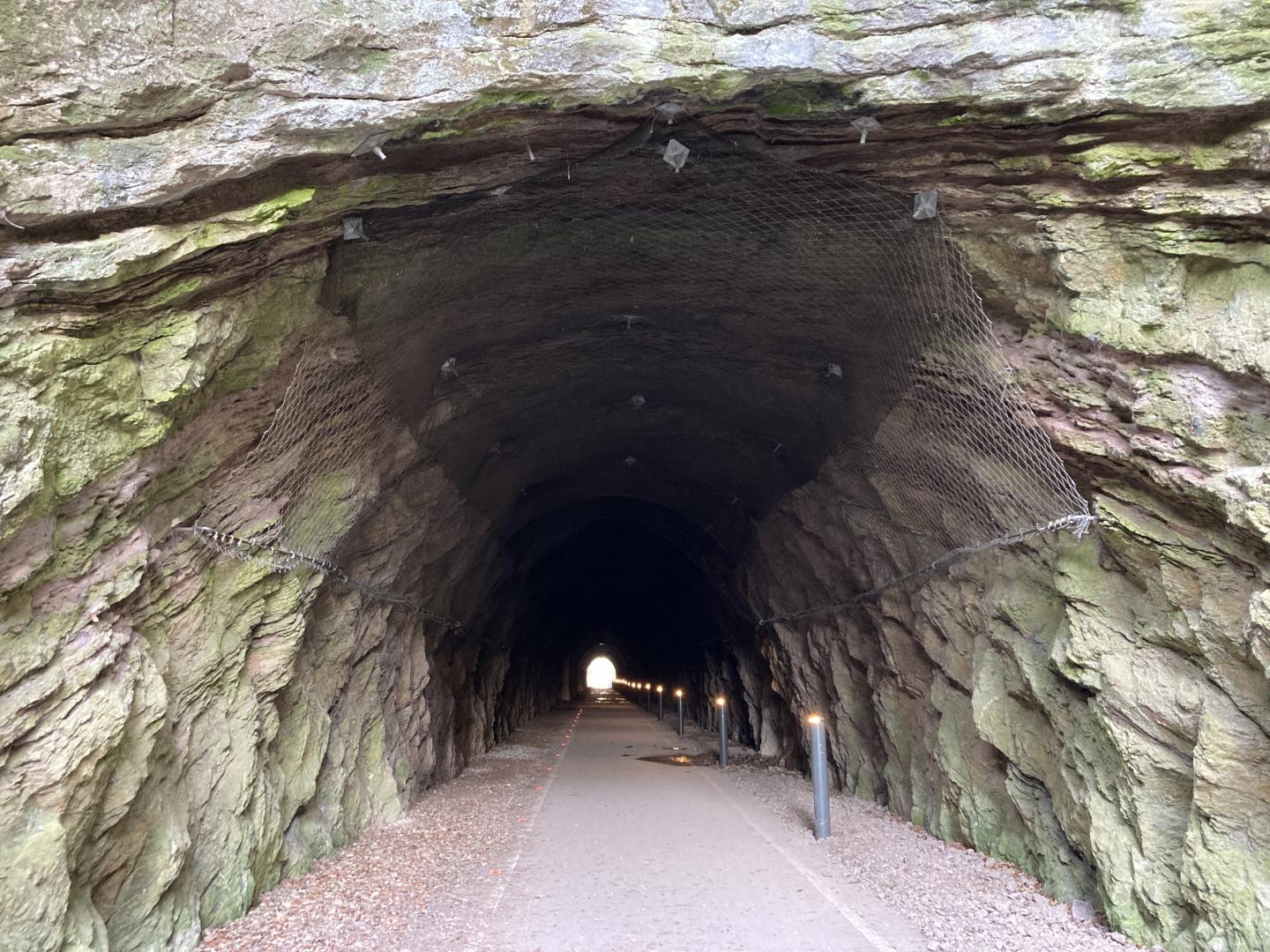 A photo of the Strawberry Line tunnel with bollard style lighting running through it.