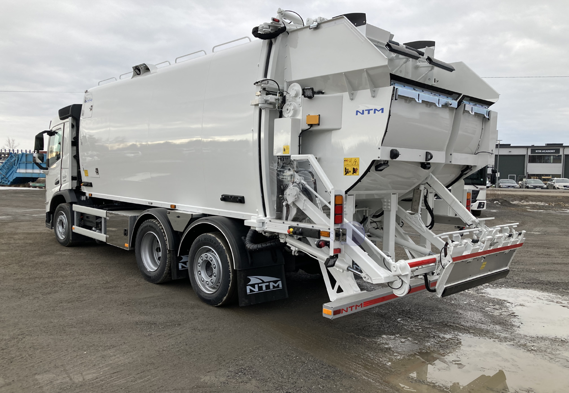 A big white vehicle with a specialist bin lift mechanism at the back