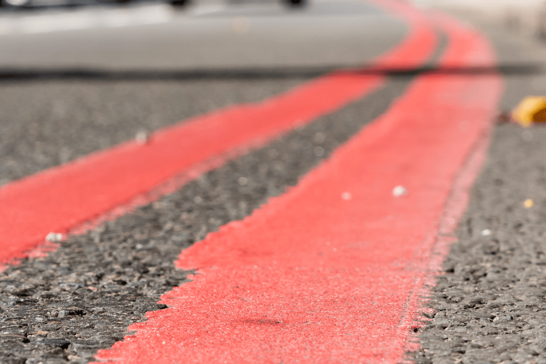 Close up of double red line markings on the side of a road