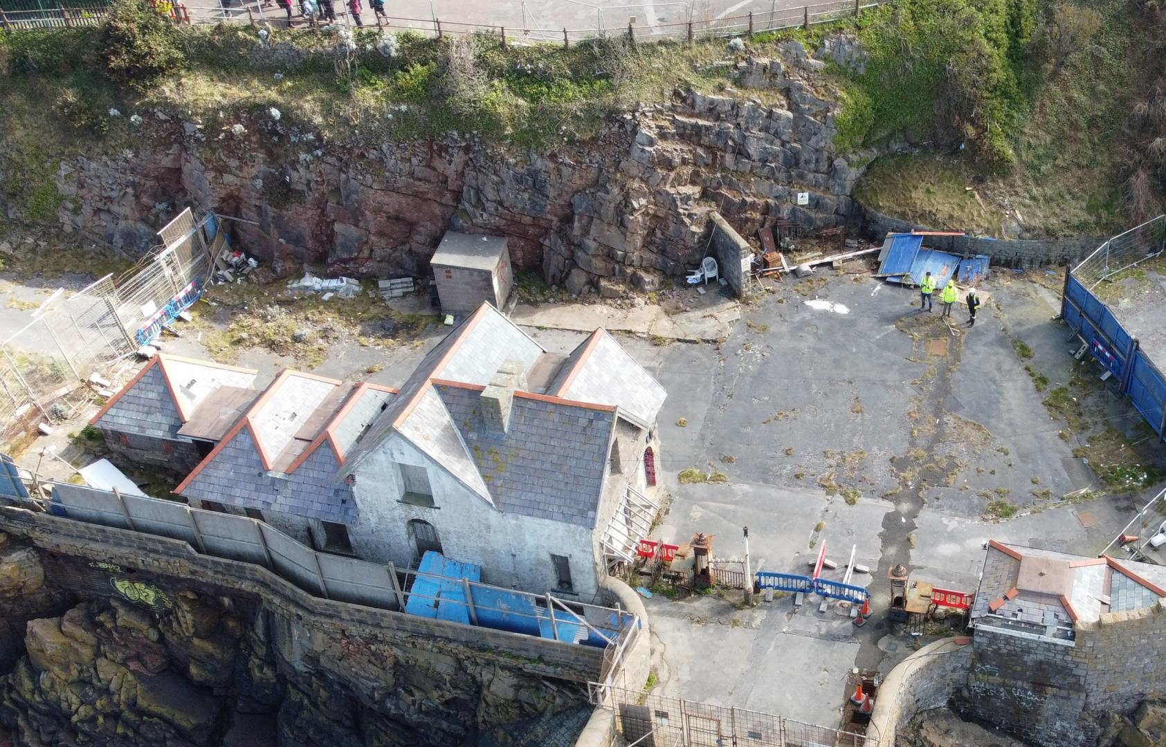 An aerial photo of the landside buildings at Birnbeck Pier looking back towards the cliff face behind and Birkett Road above. Credit: Mann Williams