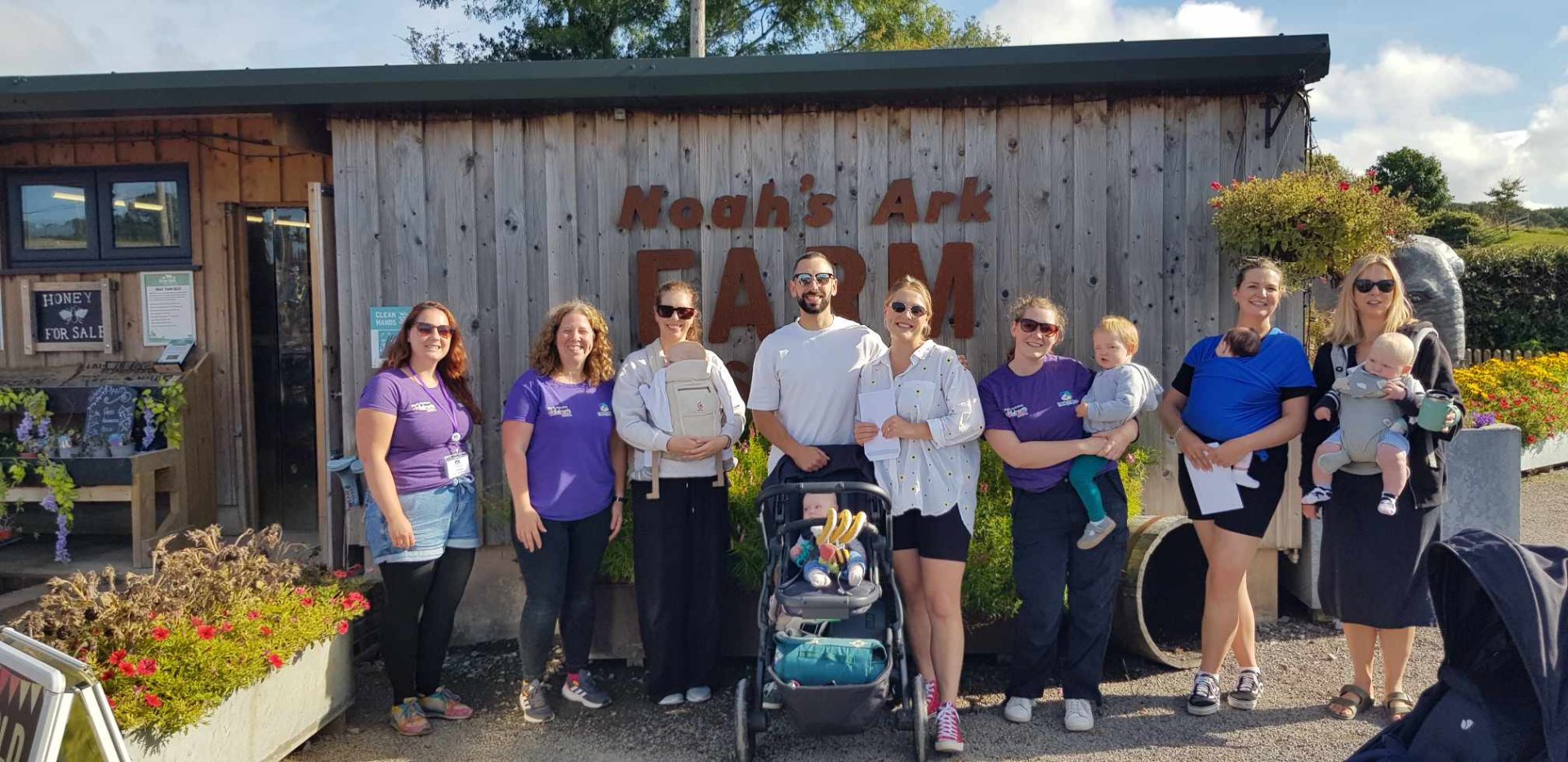 Group of volunteers, parents and babies outside Noah's Ark Zoo Farm.